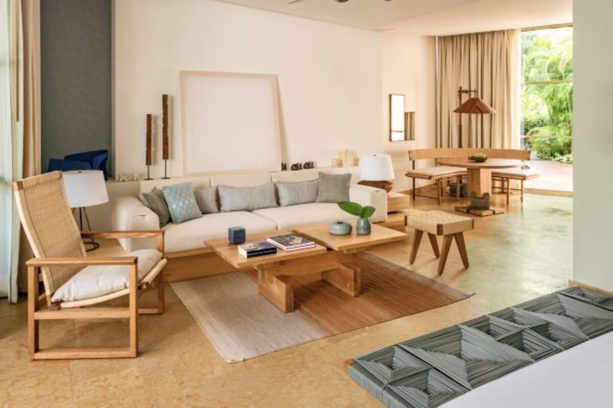 Un salon moderne comprenant un canapé, des fauteuils, une table basse et un coin repas.