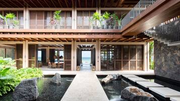 Un resort moderno con una fuente central, balcones de madera y vista al océano.