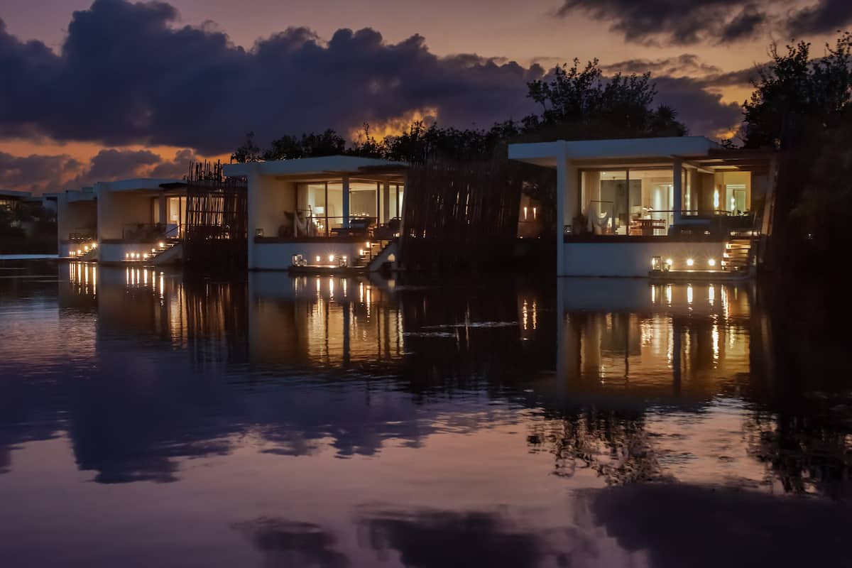 A waterfront property with modern, glass-fronted structures reflecting on the water.