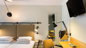 Une chambre d’hôtel avec un lit, un bureau, une chaise, une télévision et une lampe.