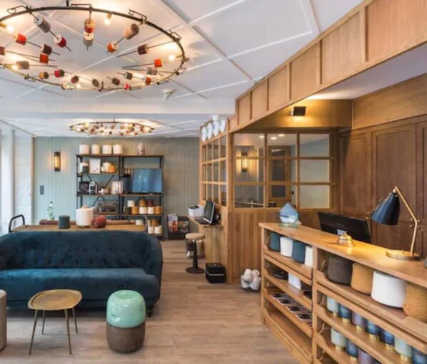 A modern interior with a blue sofa, wooden shelves, and a unique circular ceiling light fixture.