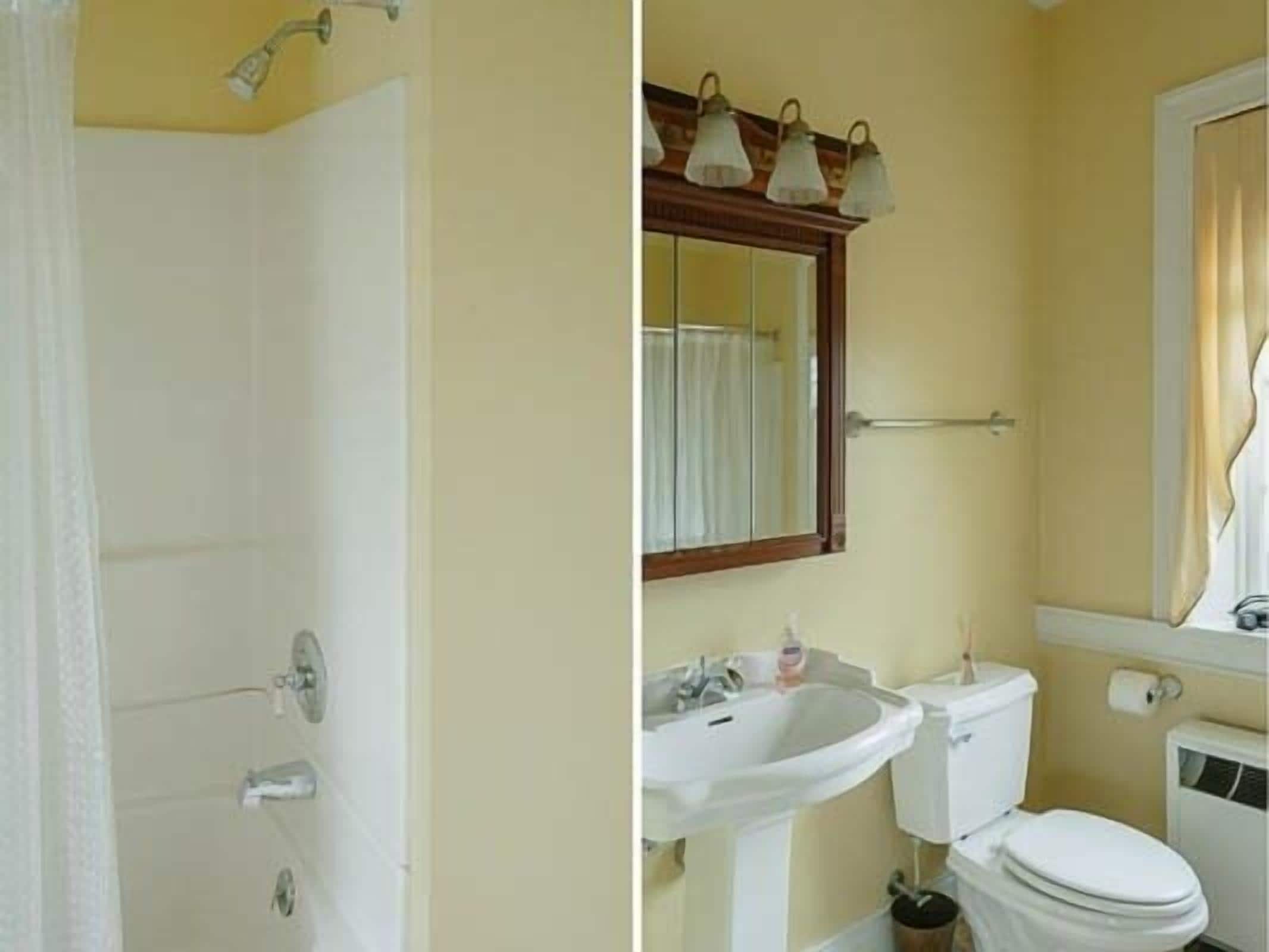 A bathroom with a shower, sink, toilet, and a mirror with lights above.