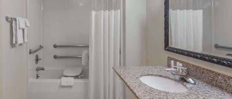 A modern bathroom with a shower, toilet, and sink.