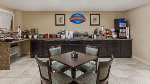 Un área de desayuno con mostrador, asientos y un letrero que dice "Baymont Breakfast Corner".