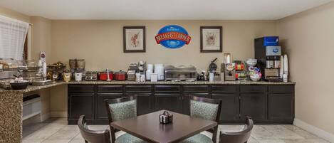 A breakfast area with a counter, seating, and a sign reading "Baymont Breakfast Corner".