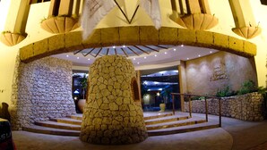 A stone archway with flags, a central stone pillar, and a staircase leading to a building entrance. - Al Liwan Suites (Doha)