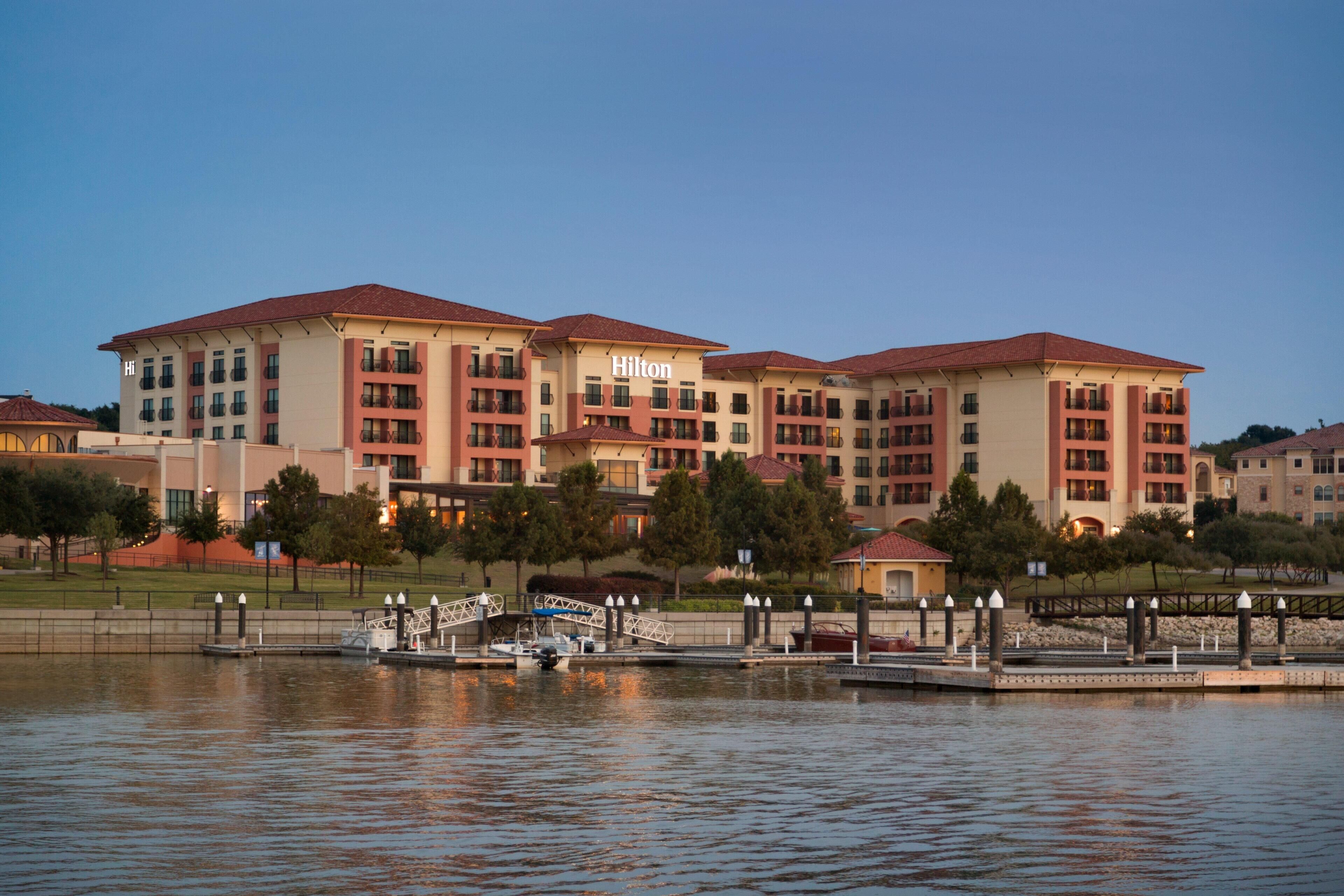 A multi-story hotel with balconies, a dock, and a bridge.