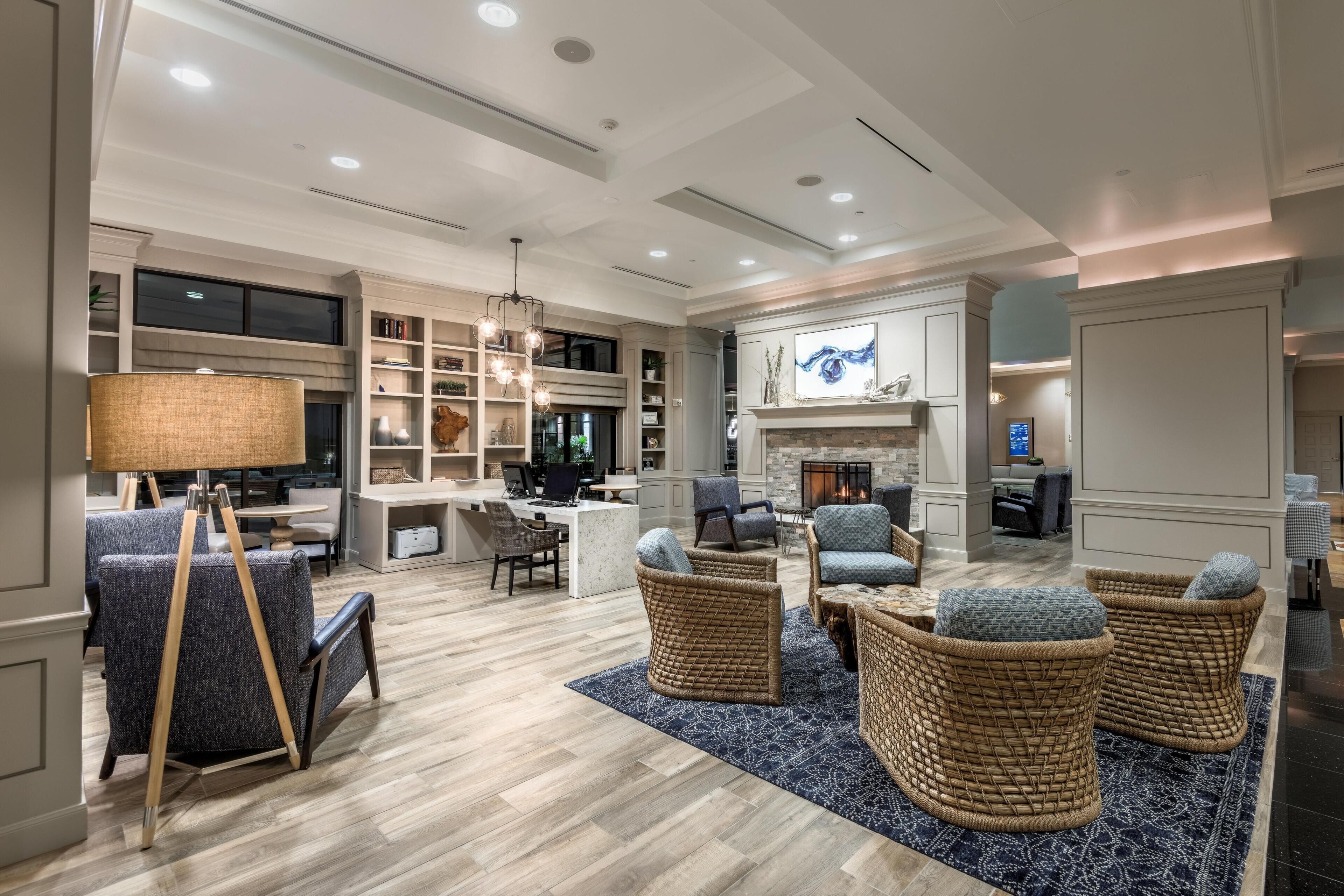 A spacious living area with a fireplace, comfortable seating, and a modern kitchen.
