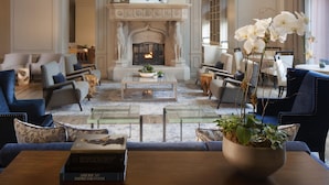 A spacious lobby with a fireplace, modern furniture, and a chandelier.