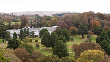 A large white building surrounded by a well-maintained lawn and trees.