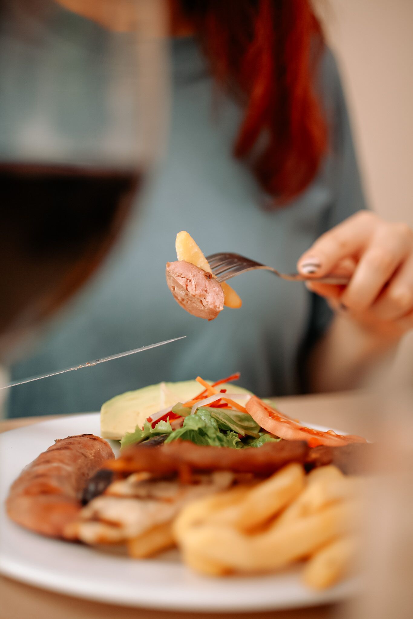 A plate with various food items including a croissant, fries, and a salad.