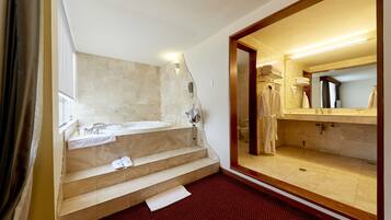 Une salle de bain d’hôtel avec un grand miroir, une baignoire et un lavabo.