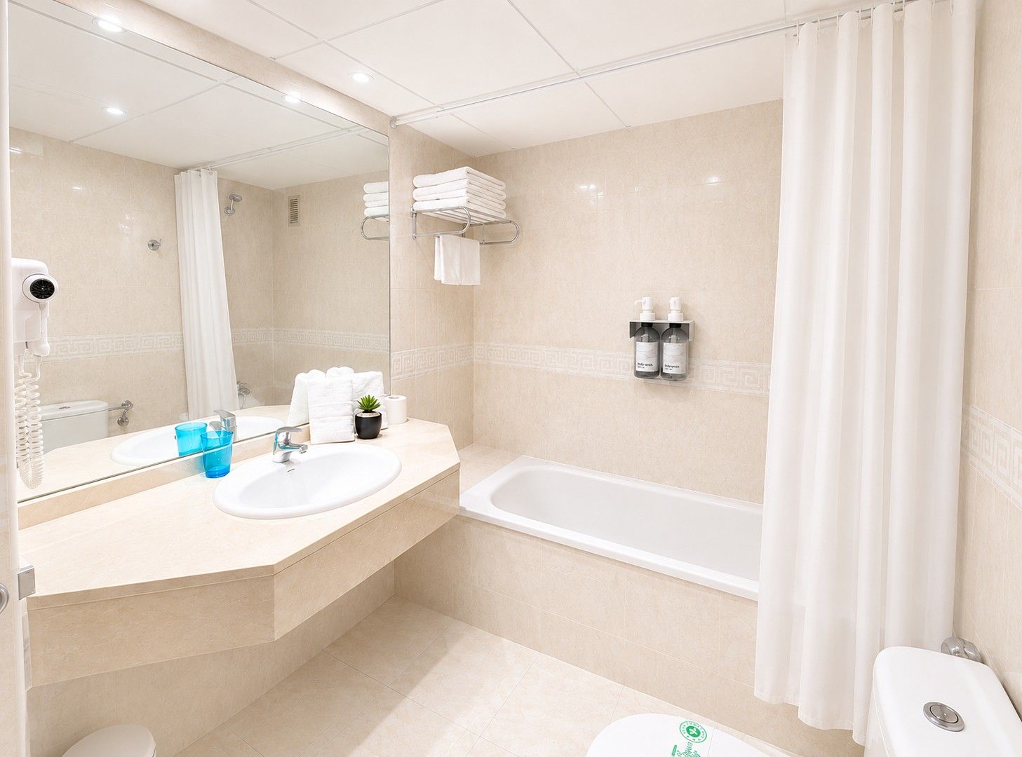 Une salle de bain moderne équipée d’une baignoire, d’un lavabo, d’un miroir et de toilettes.