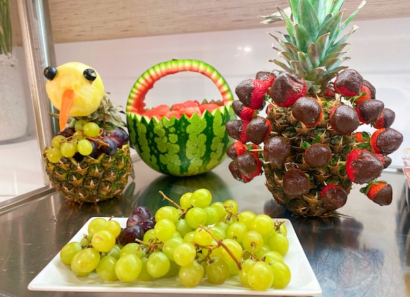 Eine Obstplatte mit Ananas, Wassermelone und Trauben.