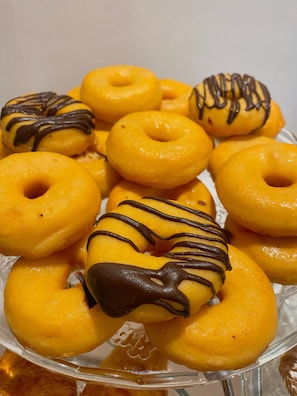 Ein Teller mit glasierter Donuts und Schokoladenglasur.