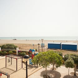 Na praia, espreguiçadeiras, guarda-sóis, toalhas de praia