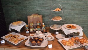 Un buffet proposant une variété de pâtisseries, de sandwichs et de condiments.