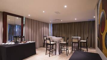 Habitación de hotel con comedor, un espejo grande y un cuadro en la pared.