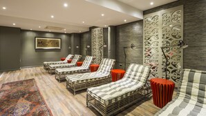 Une pièce comprenant quatre fauteuils de relaxation en osier, un tapis à motifs et un panneau décoratif mural.