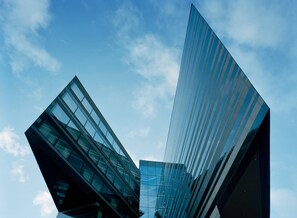 A modern building with a glass facade and angular design. - Clarion Hotel Sign (Stockholm)