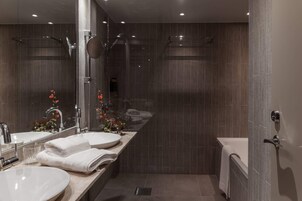 Un baño moderno con dos lavabos, un espejo grande y una zona de ducha.
