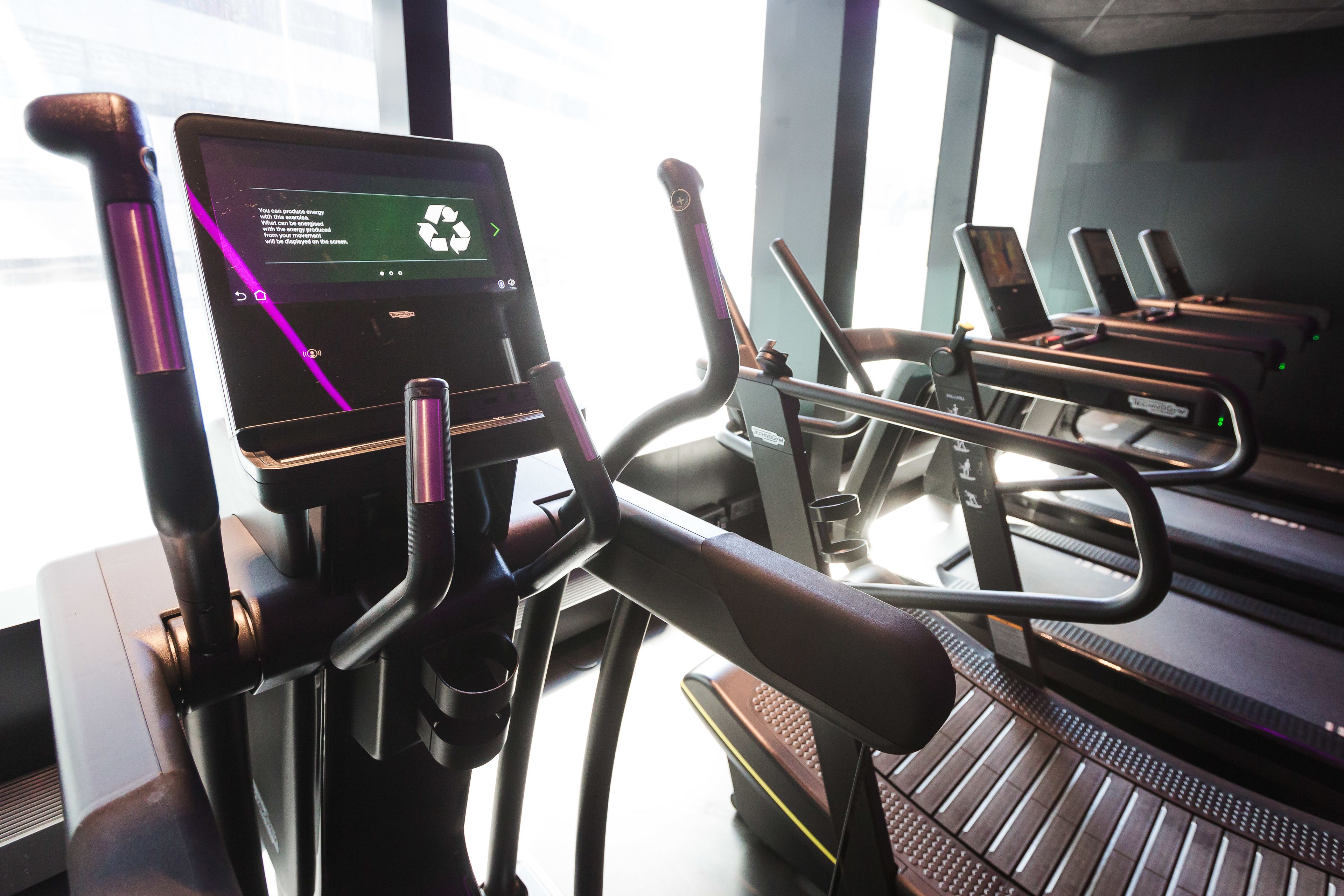 An indoor gym with stationary bikes and a digital display.