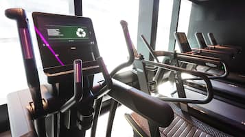 An indoor gym with stationary bikes and a digital display.