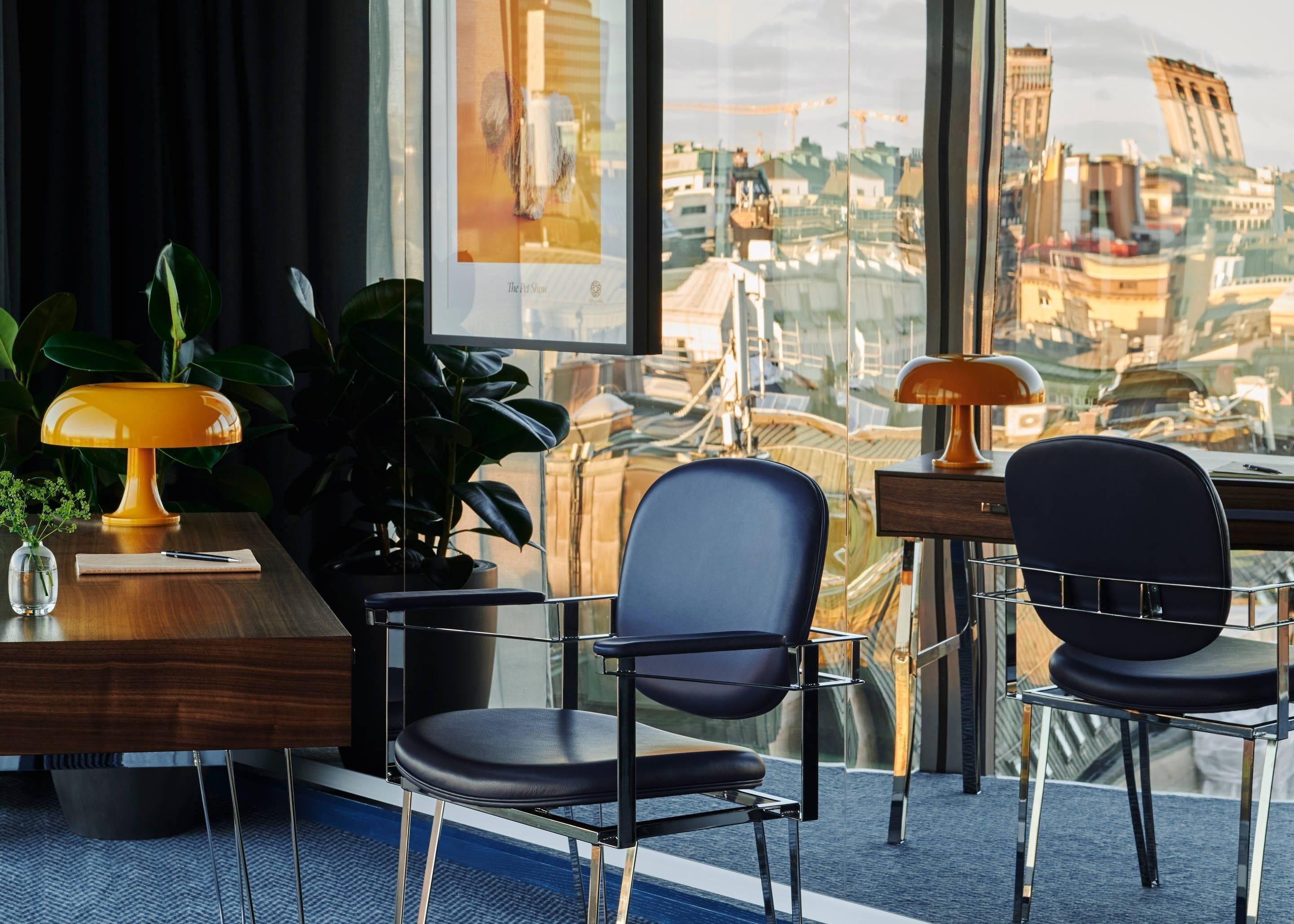 Un espace de bureau moderne comprenant un bureau, deux chaises, une lampe et une plante en pot.