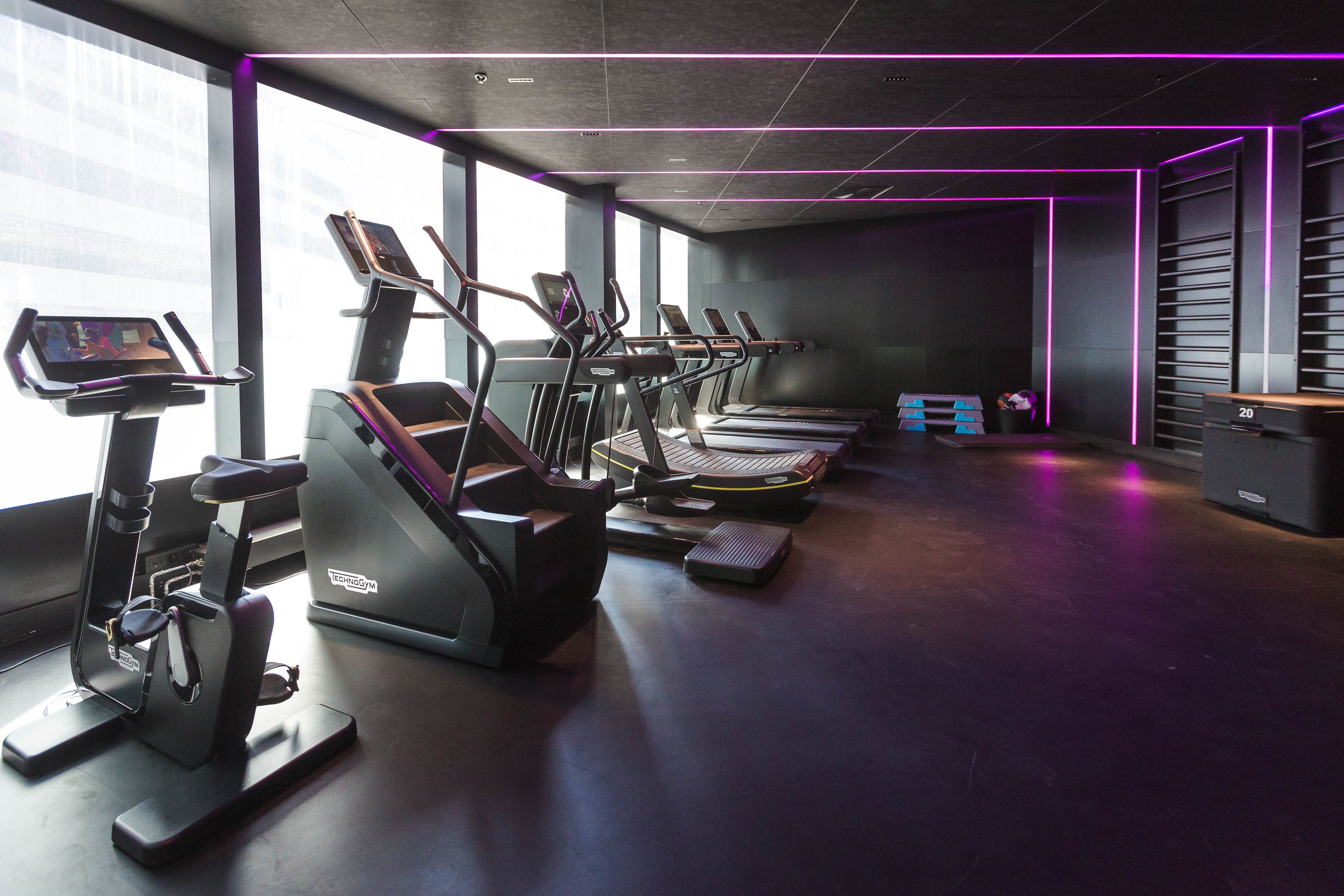 A gym with treadmills, ellipticals, and a stationary bike.