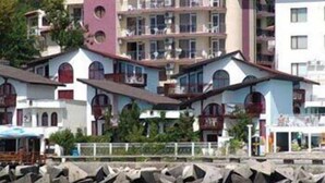 Un immeuble à plusieurs étages, doté de balcons et surmonté d’une tour centrale.