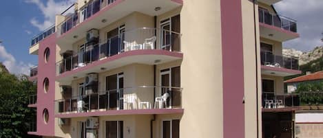 A multi-story building with balconies, windows, and a door.