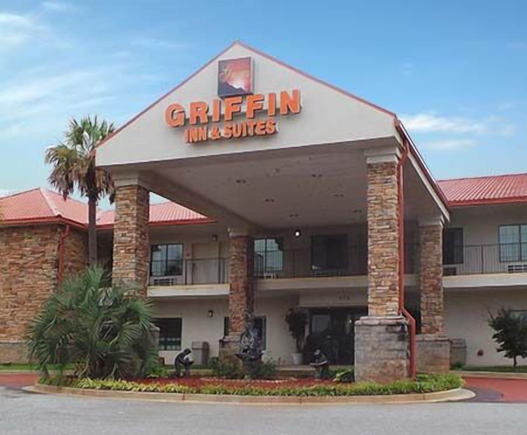 A Griffin Inn & Suites building with a red roof, stone pillars, and a covered entrance area.