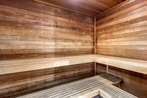 Una sauna de madera con bancos y suelo inclinado.
