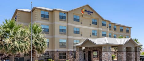 A Comfort Inn hotel with a stone facade, multiple windows, and a covered entrance.