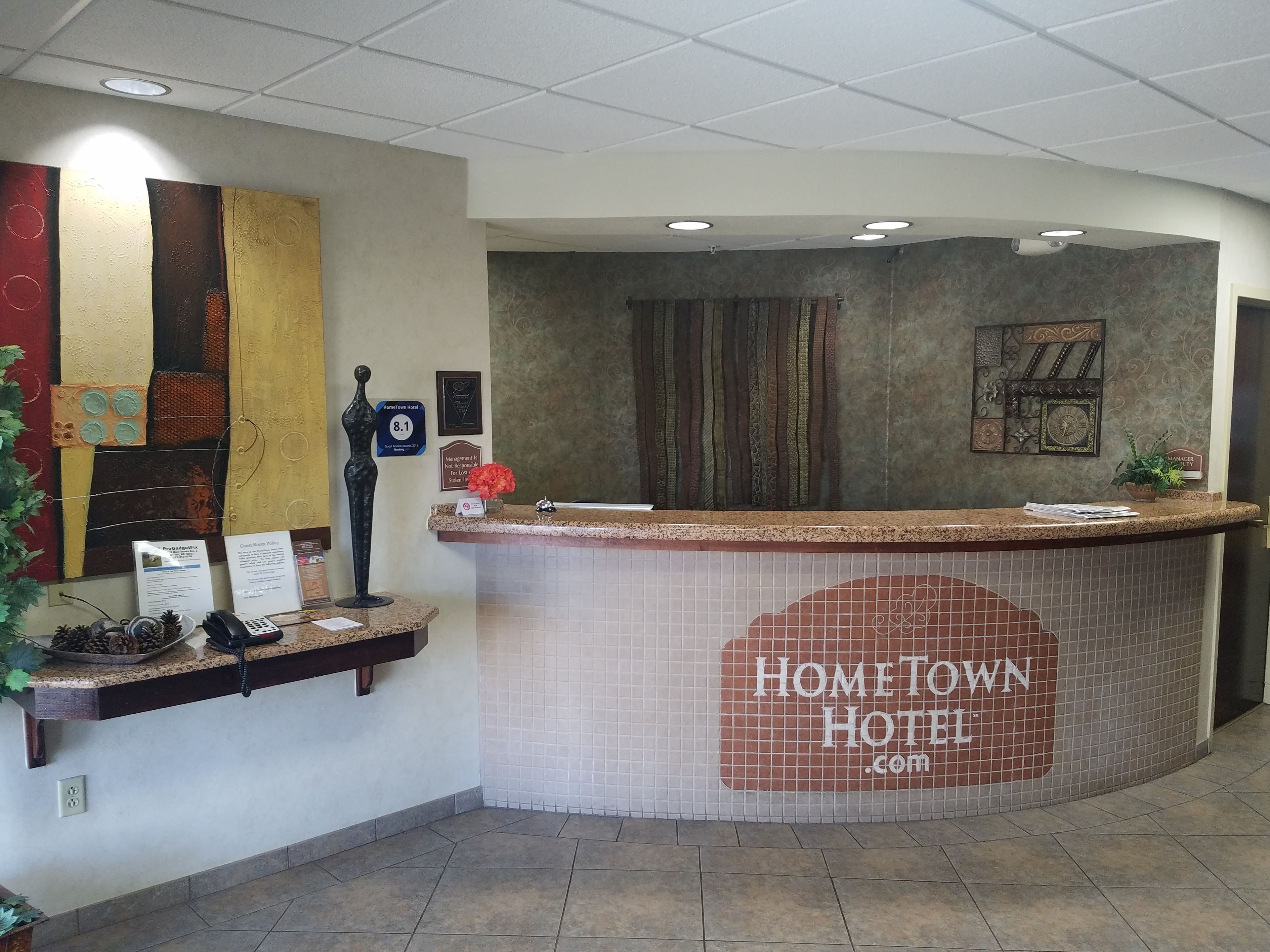 A reception desk with a "Hometown Hotel" sign, a phone, and a plant.