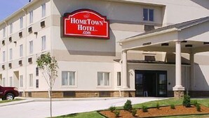 A hotel with a prominent red sign reading "HomeTown Hotel.com". - HomeTown Hotel Bryant (Bryant)