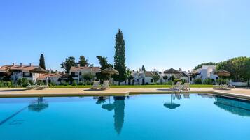 Piscine extérieure, parasols de plage, chaises longues