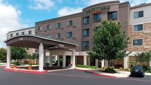 Un hotel Courtyard Marriott con entrada cubierta, varios pisos y un estacionamiento.