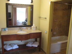 Un baño con lavamanos, espejo y ducha.