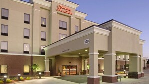 Entrada de un hotel con un letrero que dice 'Hampton Inn & Suites' y el número '109' indicando la dirección.