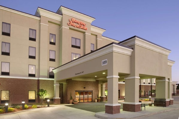 A hotel entrance with a sign reading "Hampton Inn & Suites" and a number "109" indicating the address.
