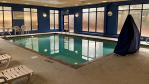 Piscina interior con señalización clara, una silla de socorrista y una zona techada.