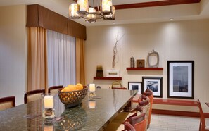 A dining area with a marble table, chairs, a candle centerpiece, and artwork on the walls. - Hampton Inn Tremonton (Tremonton)