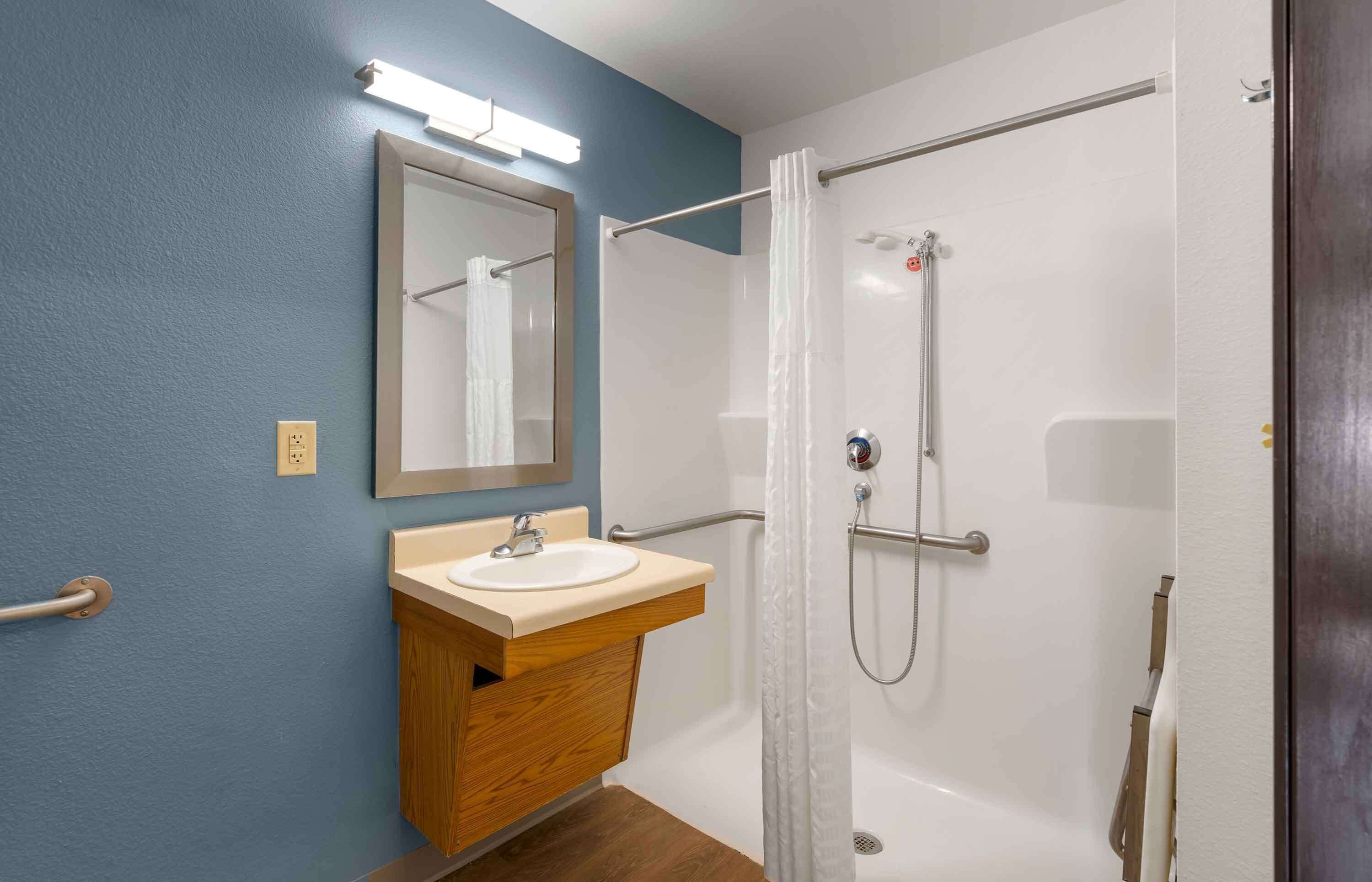 Une salle de bain avec un lavabo, un miroir et une douche.