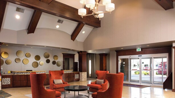 A spacious lobby with a high ceiling, a chandelier, and a reception desk. - Residence Inn by Marriott Kansas City Airport (Kansas City)