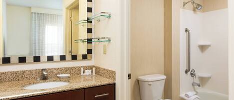A bathroom with a sink, mirror, toilet, and bathtub.