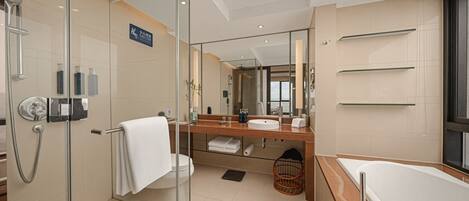 A modern bathroom with a glass-enclosed shower, a large mirror, a bathtub, and a vanity with a sink and towel rack.