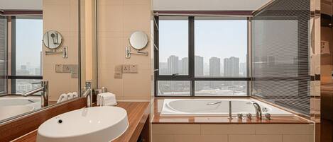 Un baño moderno con un espejo grande, dos lavamanos y una bañera.