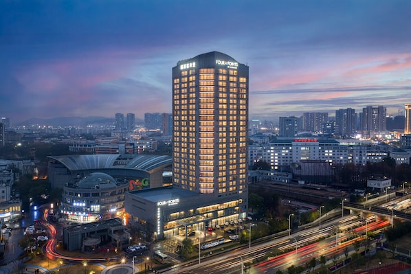 A high-rise hotel with multiple floors, surrounded by a cityscape at dusk. - Four Points by Sheraton Hangzhou, Binjiang (Hangzhou)
