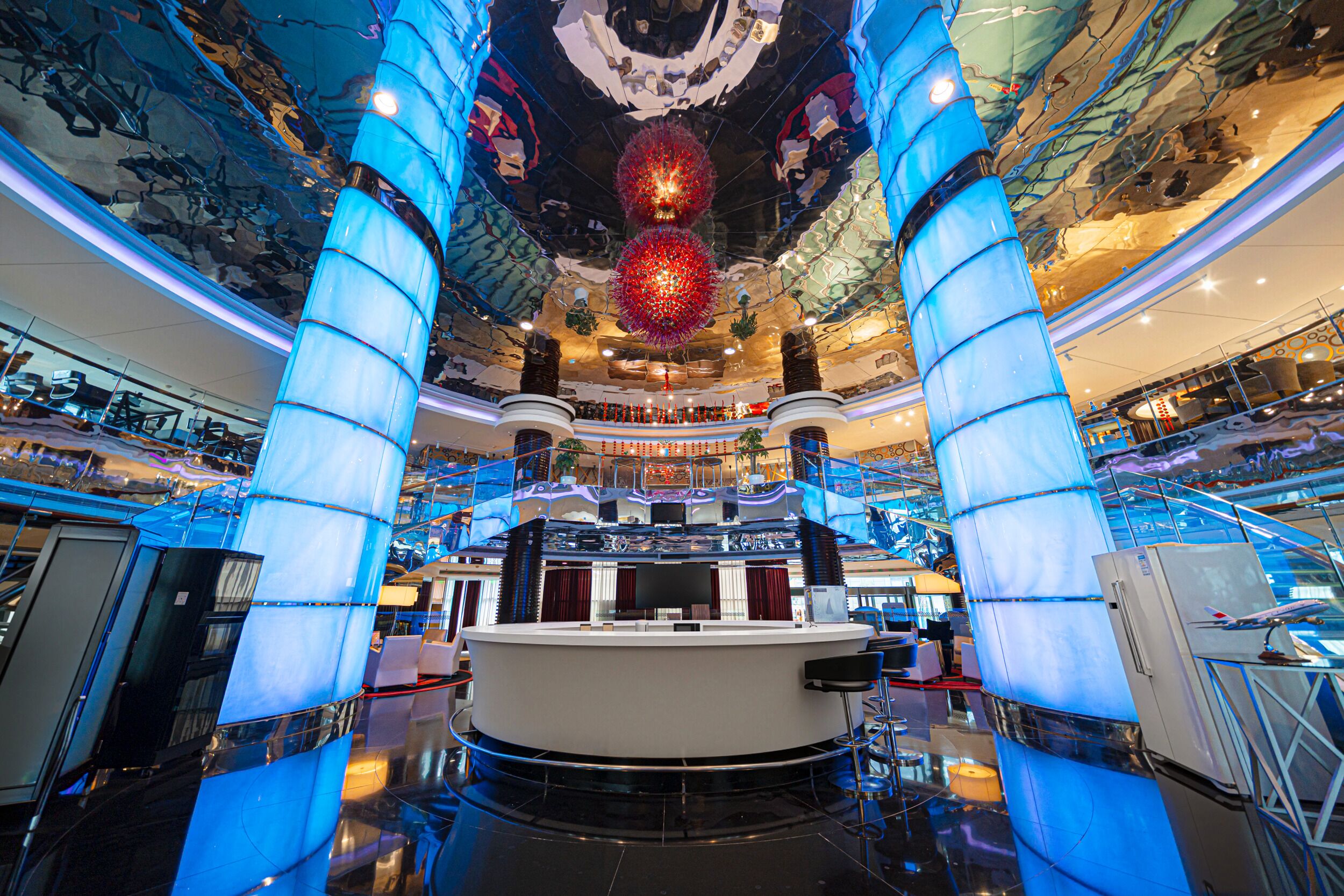 Un vaste atrium doté d’un bar central, de plusieurs niveaux et d’un plafond décoratif.